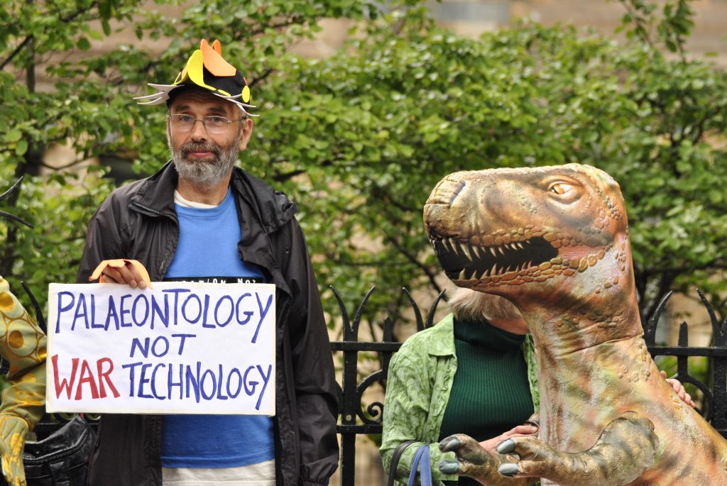 Protester with banner saying palaeontology not war technology