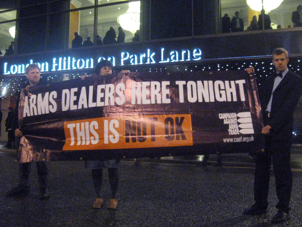 Protesters holding a banner outside the London Hilton