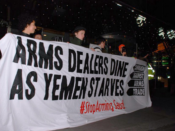 Activists hold a banner that reads &quot;Arms dealers dine as Yemen starves&quot;