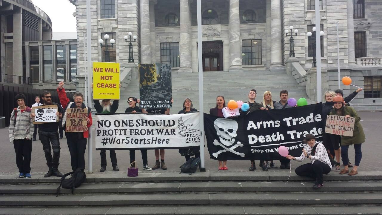 peace action wellington members line up holding banners saying &quot;arms trade death trade&quot;