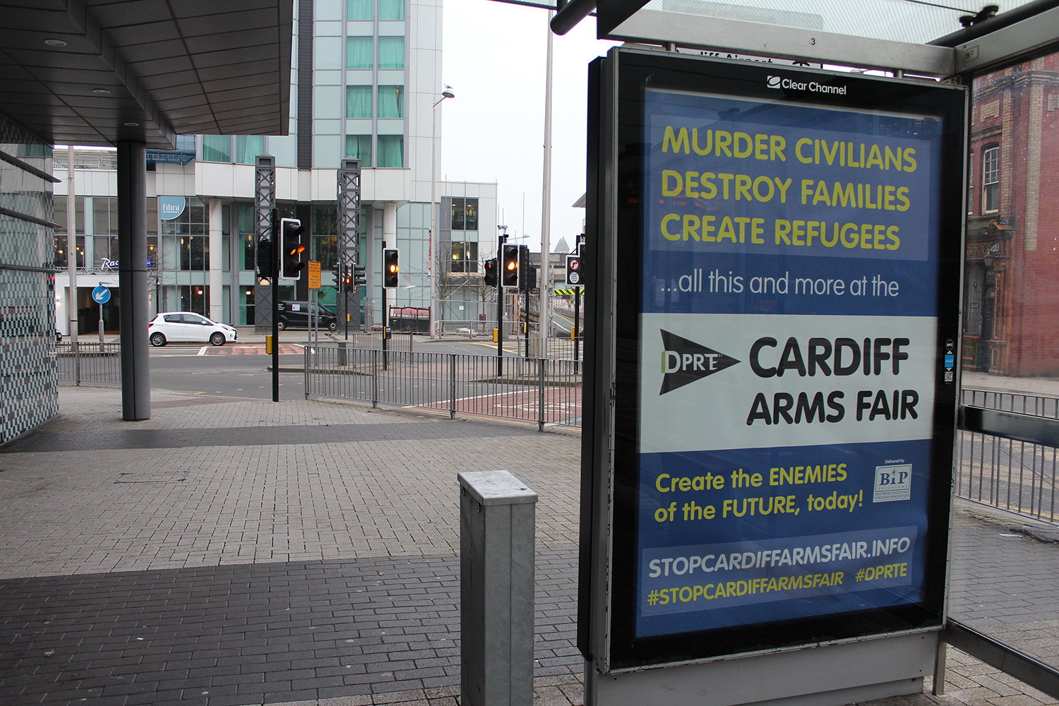 a bus stop with a spoff advert for the DPRTE arms fair , advertising war, murder and destruction at the Motorpoint Arena