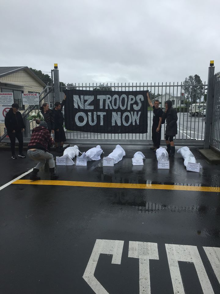 Auckland Peace Action blockade a military base with a banner reading &quot;NZ troops out now&quot;