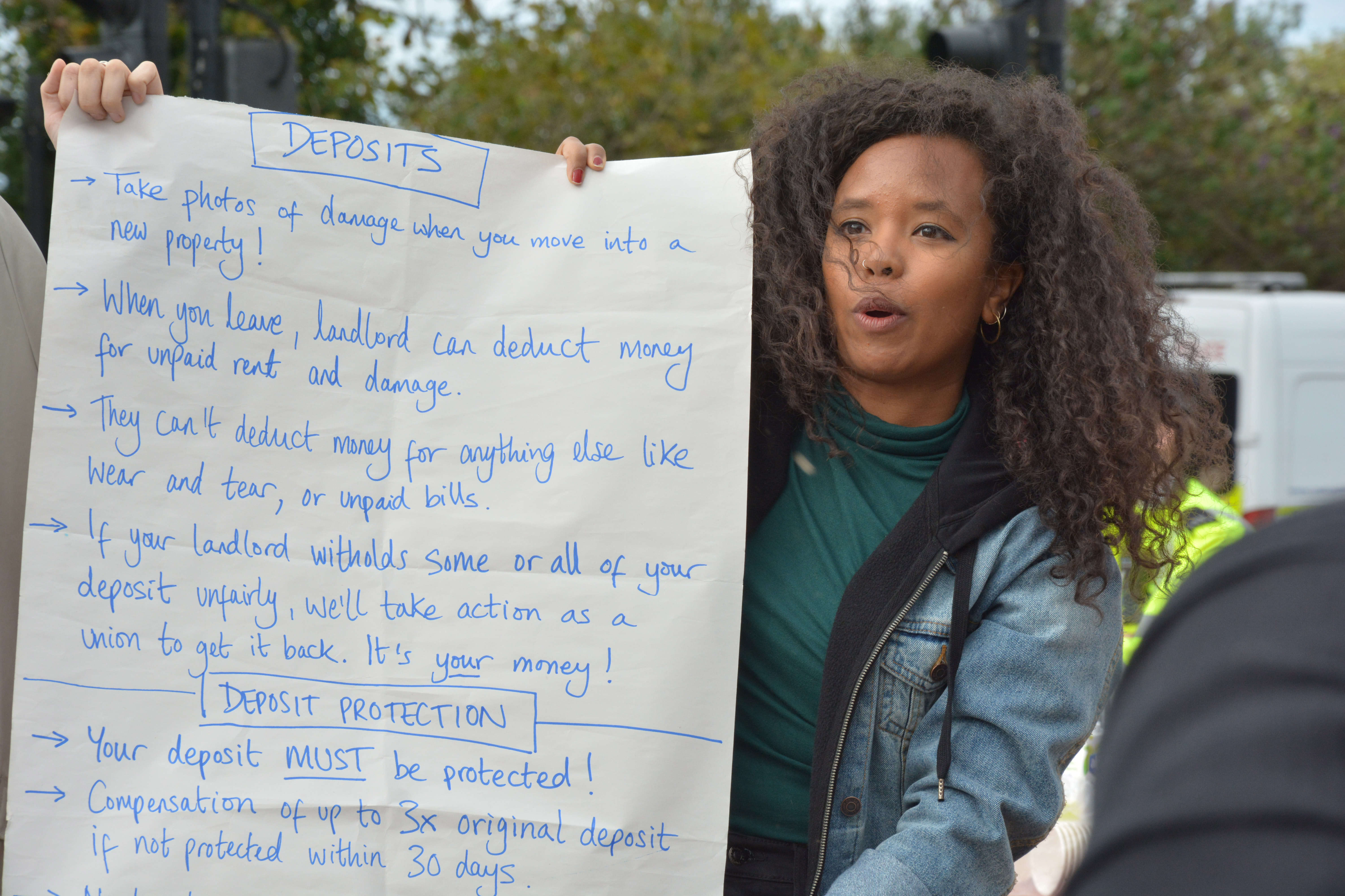 Activist with banner displaying information about renters rights