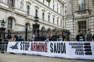 activists with banner saying stop arming saudi while outside downing street