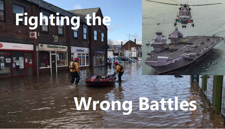 Image of a flooded high street with a rubber dinghy and two people dressed in life jackets. In the top right, smaller image of a helicopter landing on an aircraft carrier. Text on main image "Fighting the Wrong Battles!