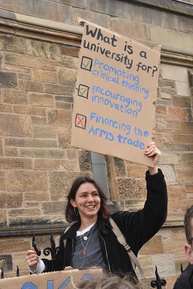 Protester outside Glasgow University calling for an end to arms company investments.