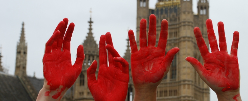 Four red hands held up in front of Parliament