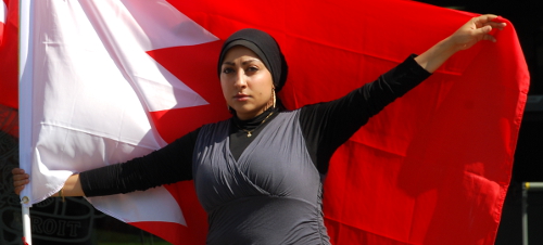 Image of a woman human rights campaigner waving Bahraini flag (behind her)
