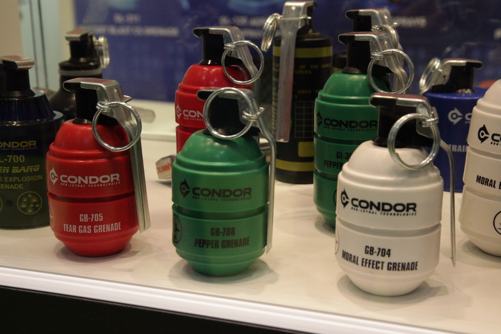 Several tear gas cannisters in green, red and white with text 'Condor' written on them.