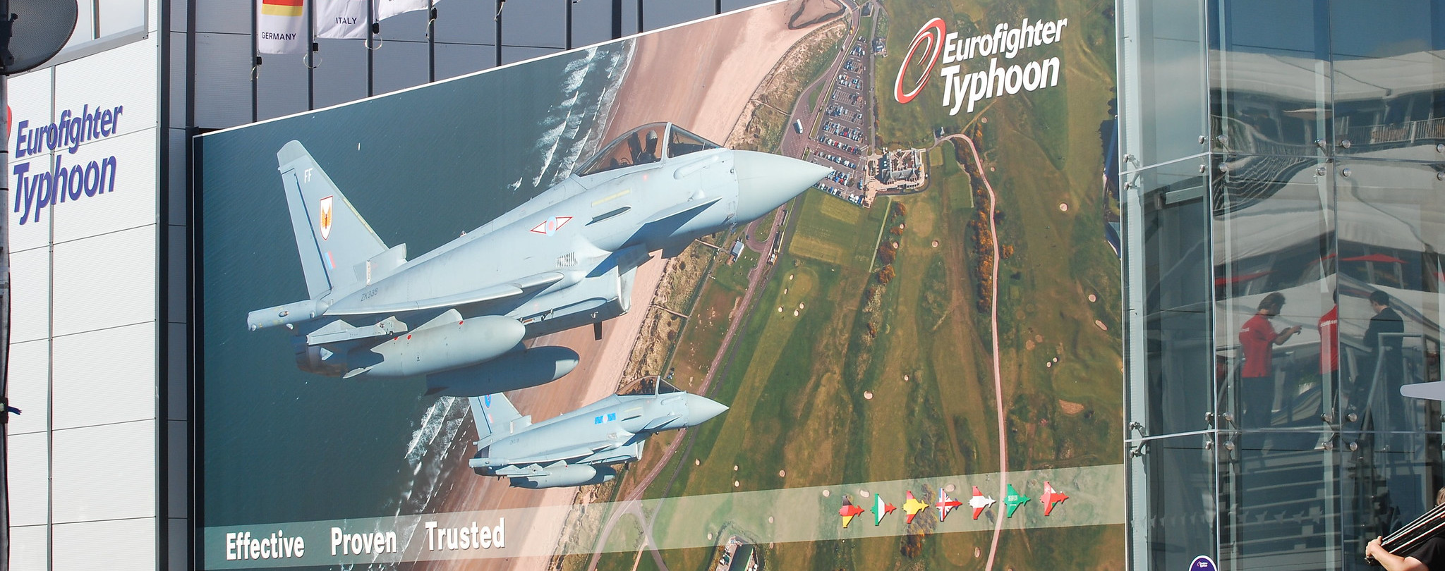 Huge digital display pictures warplanes flying from above with the ground below, and the words Eurofighter Typhoon