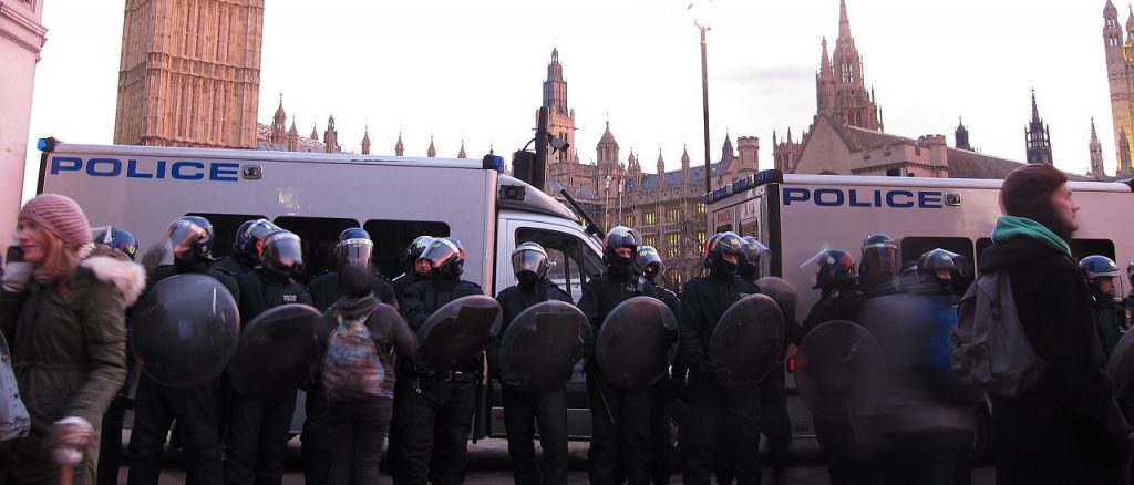 Police with shields and helmets in front of the House of Commons