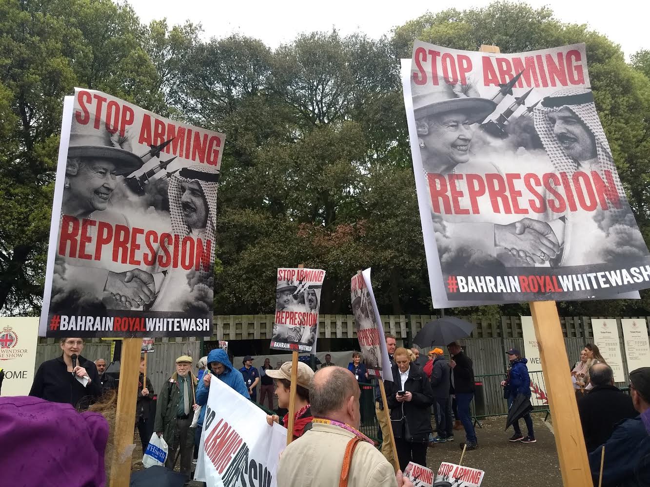 Image of protesters outside Windsor horse how with banners saying stop arming
