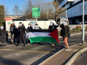 Eight protesters with a Palestine Flag block a road into Ashton Gate