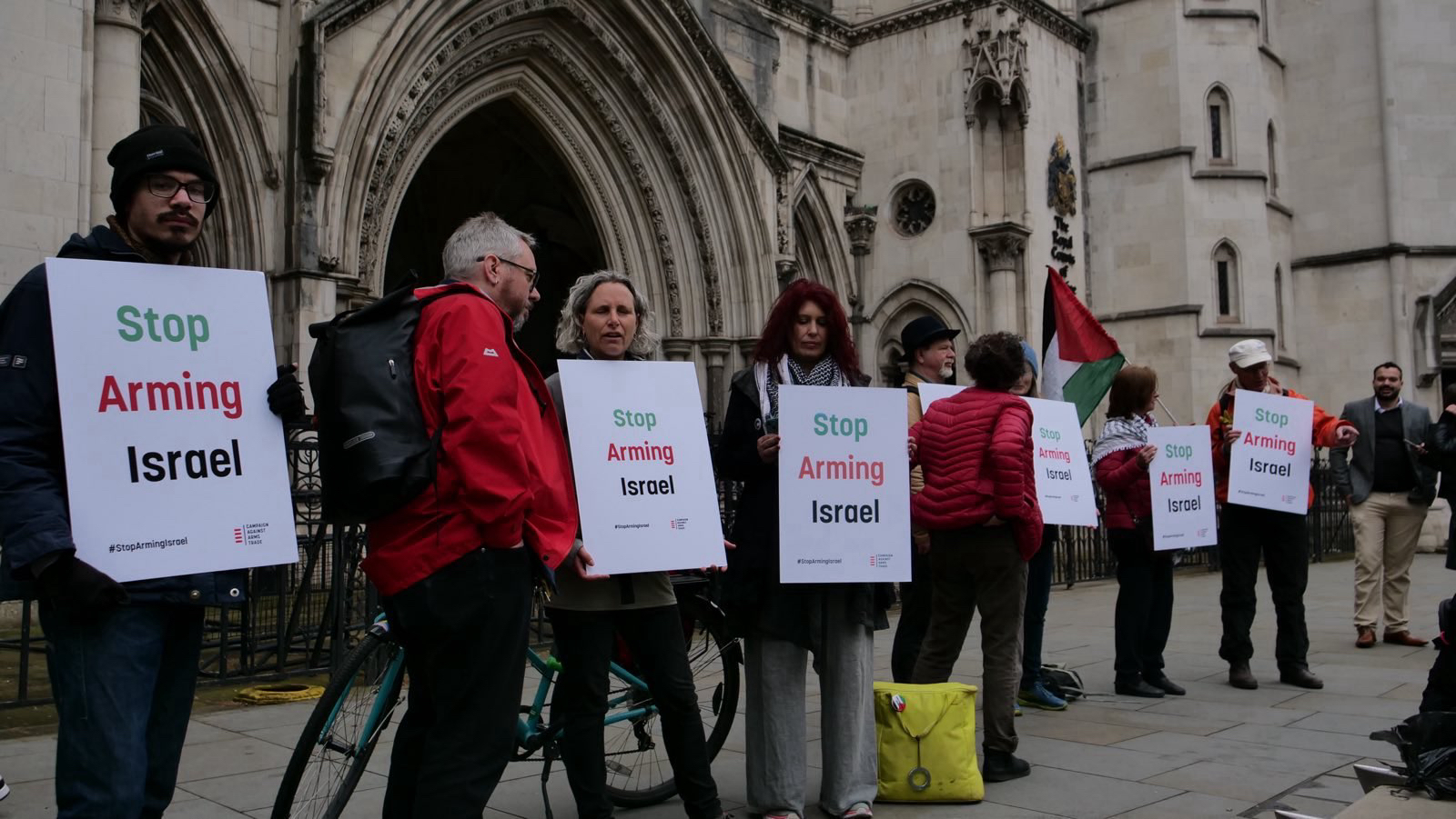 CAAT supporters with Stop Arming Israel placards stand outside the High Court in London