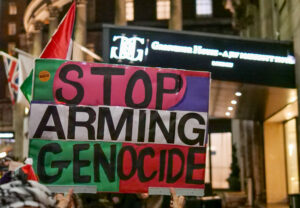 Banner reading "Stop Arming Genocide" outside the arms dealers banquet