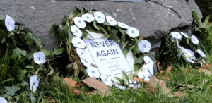 Image of wreath of white poppies saying Never Again