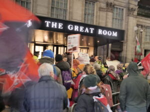A crowd of protesters wave flags outside The Great Room of a London hotel hosting the ADS dinner.