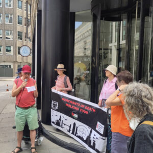 London CAAT outside Boeing in Victoria Street with two campaigners holding the Merchants of Death Tour banner